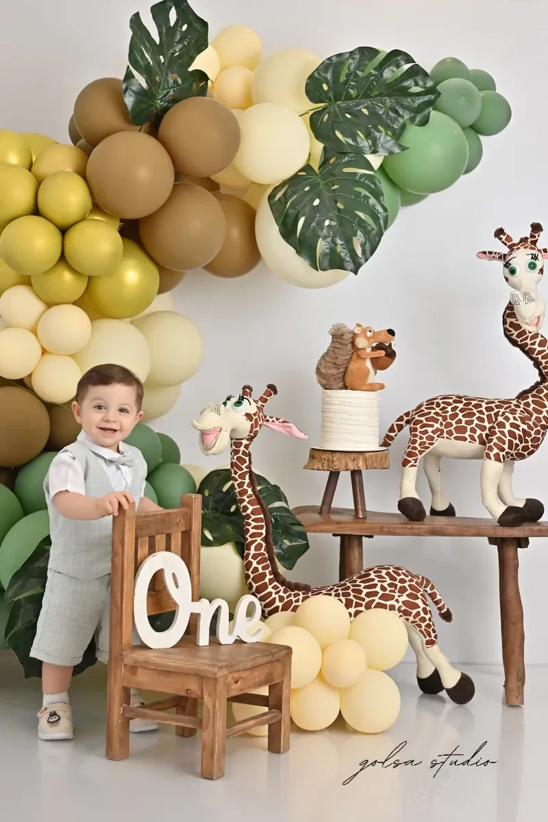 عکاسی تولد یک سالگی در استودیو گلسا با بادکنک و کیک و عروسک زرافه و ثندلی چوبی